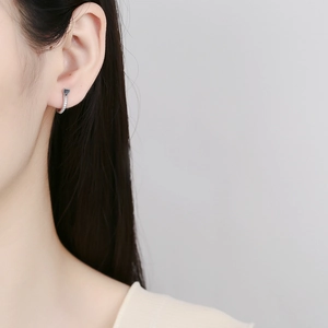 Close-up of minimalist 925 sterling silver heart hoop earrings with pavé crystals