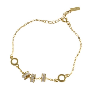 Détail du bracelet en argent S925 doré avec breloques cylindriques serties de zircons