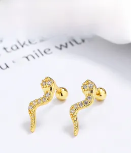 Macro shot of 925 silver snake stud earrings with white zircon and gold plating