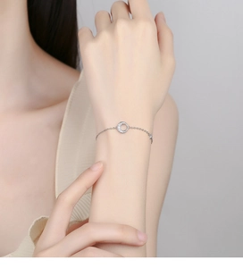 Gros plan d'un bracelet en argent 925 avec breloque lune sur le poignet d'une femme