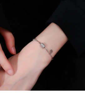 Détail d'un bracelet en argent 925 avec cylindre pavé de cristaux et pendentif pièce