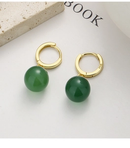 Macro detail of S925 sterling silver stamp on gold hoop earring with green agate bead