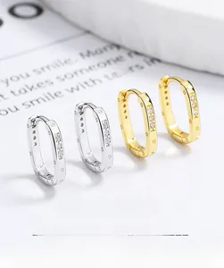 Detail of square zircon hoop earrings in gold and silver finish with gemstone inlay