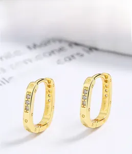Macro detail of 18K gold plated S925 silver rectangular earrings with zircon inlay