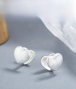 Macro shot of 925 sterling silver heart earrings with matte brushed finish and silver plating