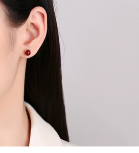 Nahaufnahme eines 925er Sterling Silber Ohrsteckers mit roter Achatperle am Model