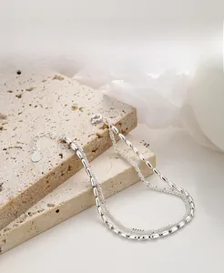 Detail of 925 sterling silver double-layer bracelet with rice grain beads and heart tag
