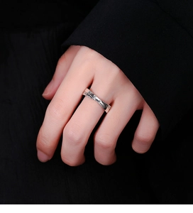 Détail d'une bague croisée en argent vintage avec gravure Keep Smile sur une main