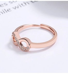 Détail macro de bague infini en or rose avec zircons et anneau ajustable de luxe