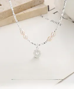 Detail of S925 sterling silver necklace with heart pendant and freshwater pearls
