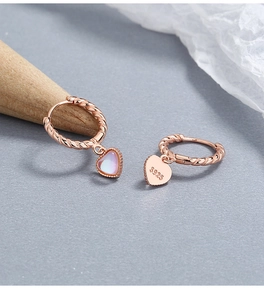 Detail of rose gold S925 silver hoop earrings with heart-shaped moonstone pendants