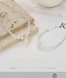 Detail of 925 sterling silver necklaces with pearls and crushed silver on travertine stone