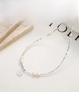 Detail of 925 sterling silver beaded necklace with natural pearls and a heart pendant