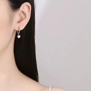 925 sterling silver heart moonstone hoop earrings worn by a model in a minimalist style