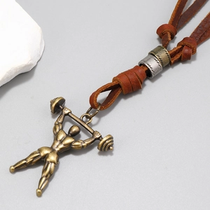 Détail macro d'un pendentif fitness en bronze avec culturiste sur cordon en cuir