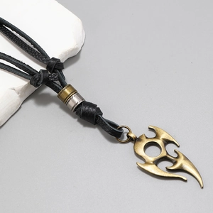 Macro detail of bronze flame pendant with layered leather cords and textured beads