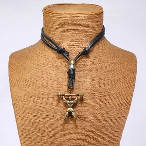 Détail du pendentif haltérophile en bronze vintage sur un collier en cuir tressé noir