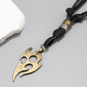 Detailed view of tribal flame pendant with black braided leather cord and metal rings
