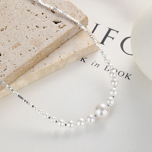 925 silver necklace with gradient pearls and box chain on textured stone background