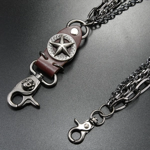 Close-up of triple-layered punk metal jean chain with star pendant and leather detail
