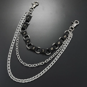 Close-up of triple-layered punk trousers chain with silver spikes and black leather band