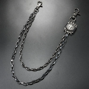 Detail of multi-layer metal wallet chain featuring gothic cross medal and punk spikes