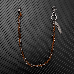 Detail of punk hip hop wallet chain with silver metal, brown suede, and feather pendant