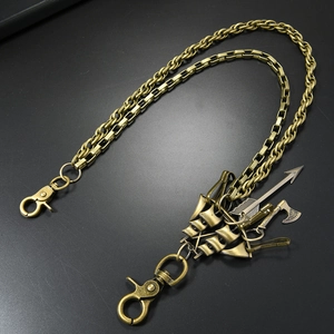 Detail of vintage multilayer pant chain with axe and arrow pendants on black background