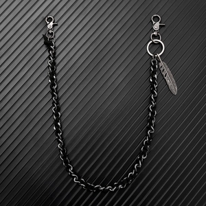 Detail of woven metal trouser chain featuring a silver feather pendant and lobster clasps