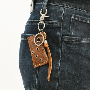 Retro brown leather keychain lighter holster hanging on denim jeans belt loop