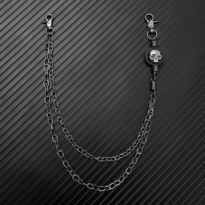 Detail of dark gunmetal punk pants chain with a skull charm and double layered links