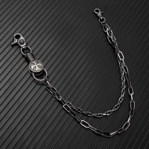 Detail of double-layer punk pants chain with cross emblem on gunmetal link hardware