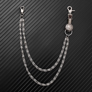 Detail of double-layer punk chain with eagle charm and carabiner clips on dark background