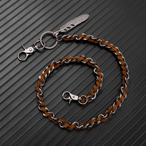 Detail of silver Cuban chain with brown suede cord and decorative feather charm