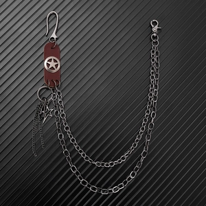 Close-up of double metal chains with leather patches and star charms on a pants chain