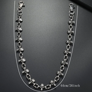 Detail of 64cm punk skull pant chain with lobster clasps on a dark textured surface