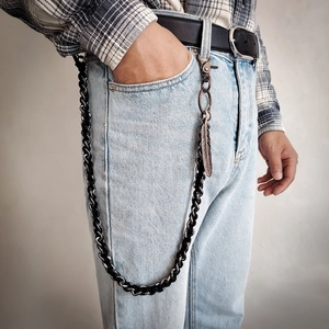 Detail of punk hip-hop waist chain with woven rope, silver links and feather pendant