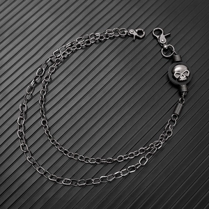 Detail showing gunmetal double-layer pants chain with 3D skull charms and lobster clasps