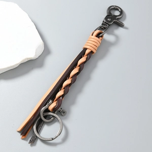 Detail of handcrafted woven cowhide leather keychain with vintage metal lobster clasp