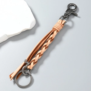 Detailed close-up of handmade woven leather keychain with vintage metal horseshoe buckle