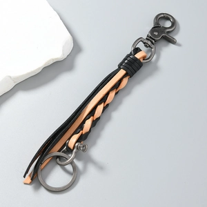 Close-up of hand-woven leather keychain with vintage horseshoe buckle and metal hook