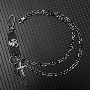 Détail d'une chaîne de ceinture punk à couches avec écussons en cuir et pendentif croix