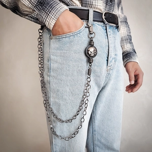 Detail of multi-layer metal trousers chain with gothic skull pendant and lobster clasp