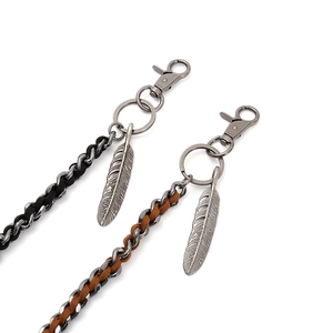 Punk rock style woven metal trouser chains with feather pendants in black and brown leather