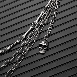 Detail einer mehrlagigen Gothic-Hosenkette in Silber mit Totenkopf und Knochen-Elementen