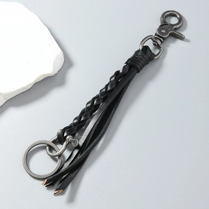Close-up of handmade woven black leather keychain with vintage silver horseshoe clasp detail