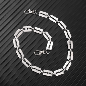 Punk style stainless steel razor blade link pants chain with lobster clasps on black surface