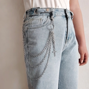 Silver multi-layer waist chain with cross pendant on light blue denim jeans