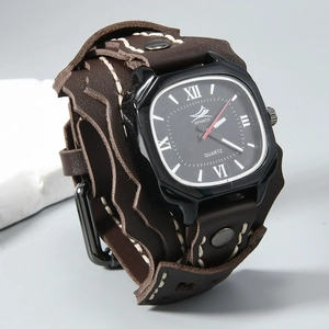 Detail of wide brown leather watch strap with white stitching and punk rivets
