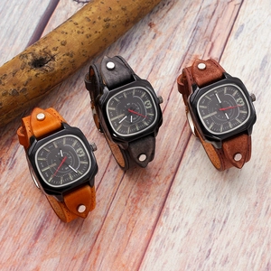 Detail showing vintage square leather watches with matte black cases and silver rivets